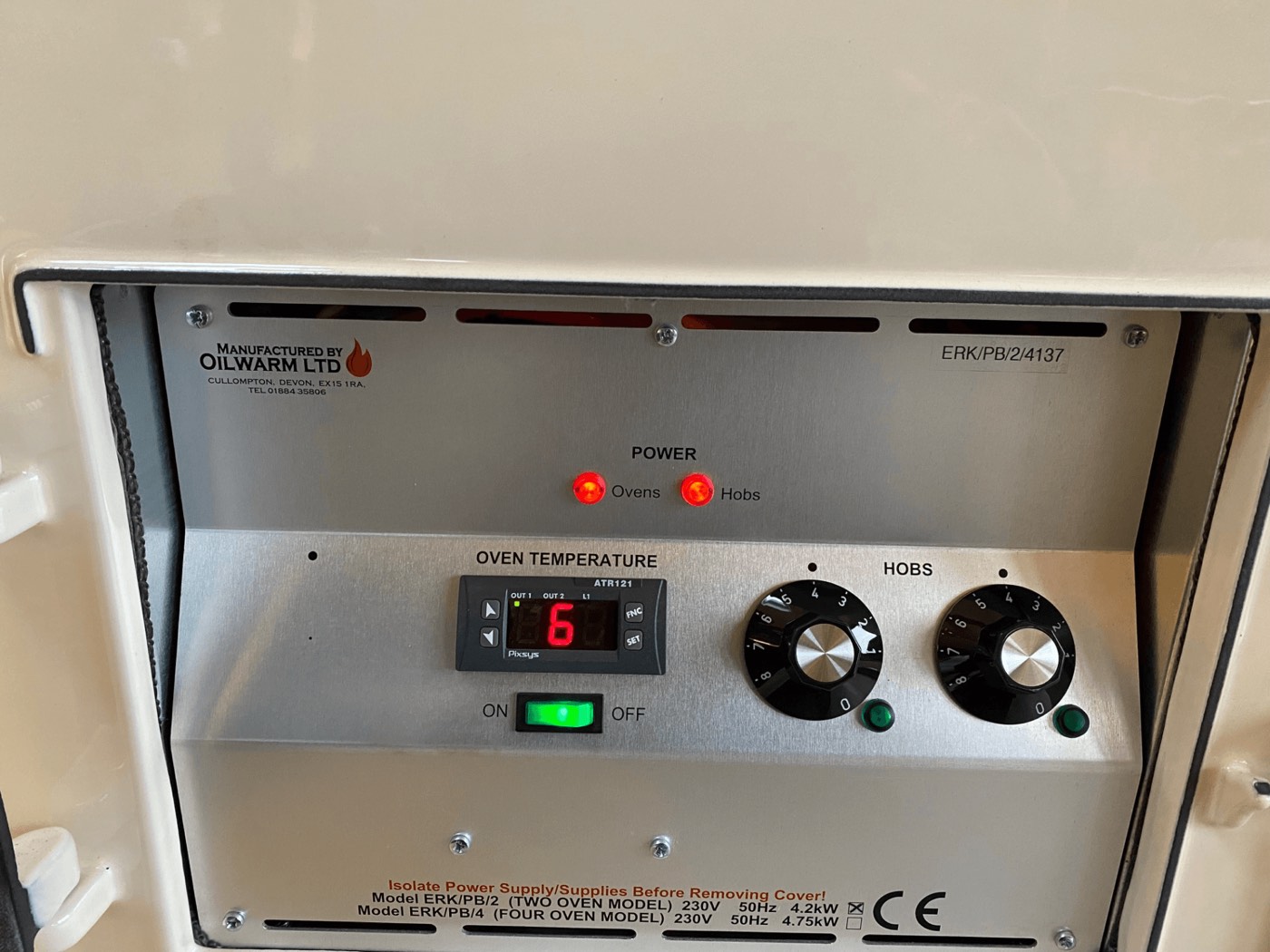 An Electrickit control panel inside a cream Aga, with a digital oven temperature readout, two hob dials and power lights